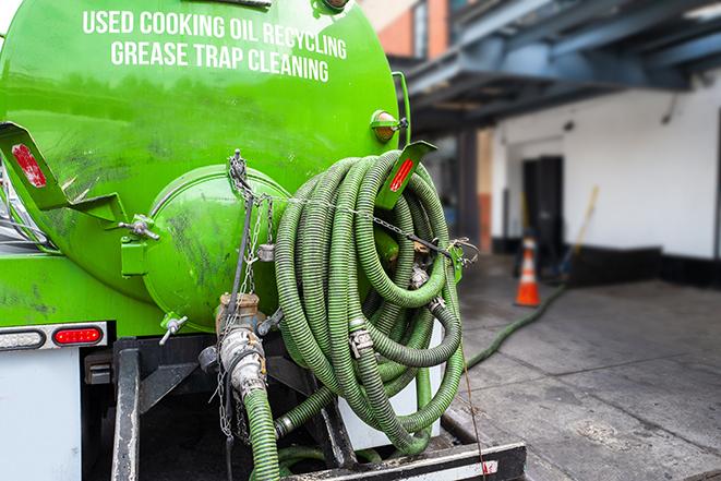 a technician pumping a grease trap in a commercial building in Maplewood